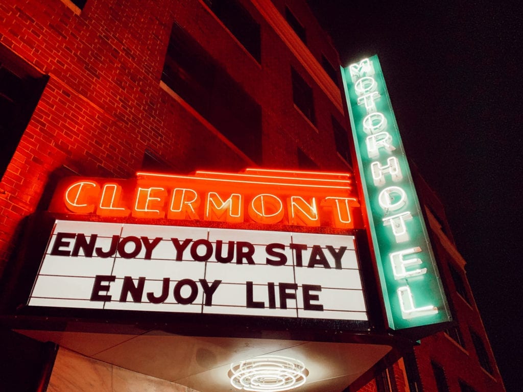 "Enjoy Your Stay, Enjoy Your Life" neon marquee outside Hotel Clermont Atlanta