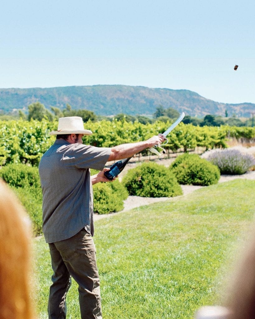 James Hall sabers a bottle of Patz & Hall Brut sparkling wine in Sonoma.