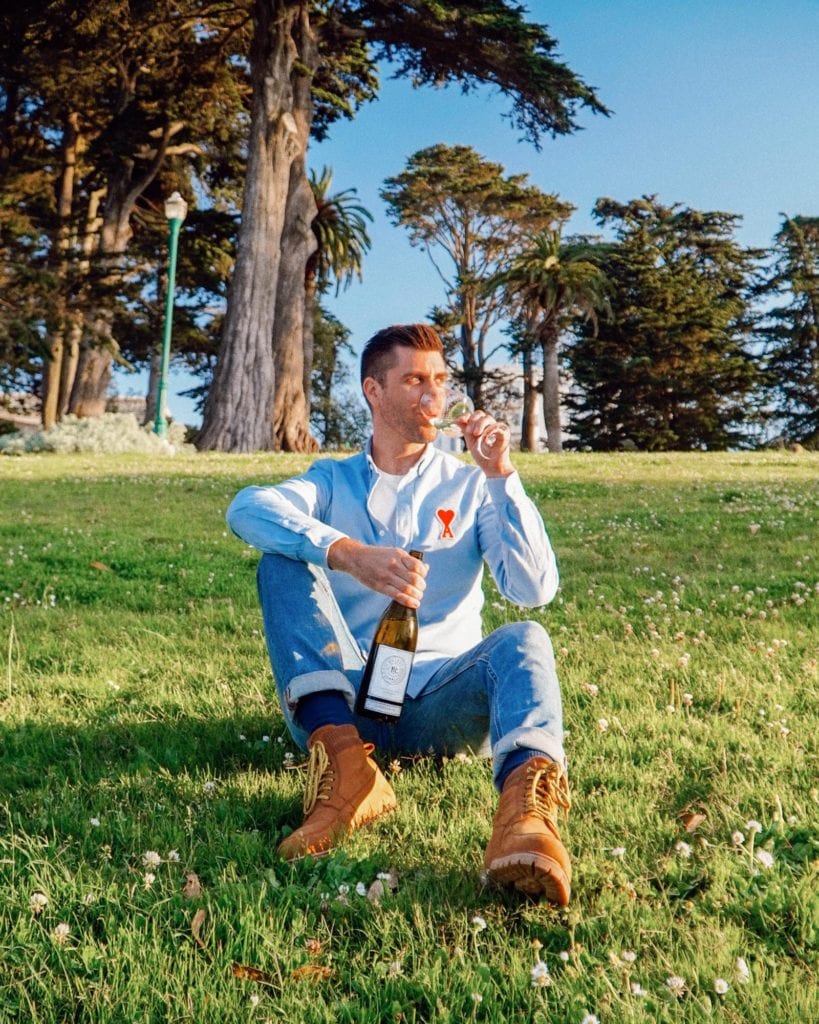 Kyle Legg, The Cosmopolitan Man, sipping Priest Ranch wine in San Francisco's Alamo Square Park.